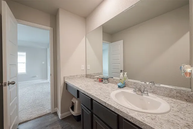 a backyard of a house with a fountain plants and large tree