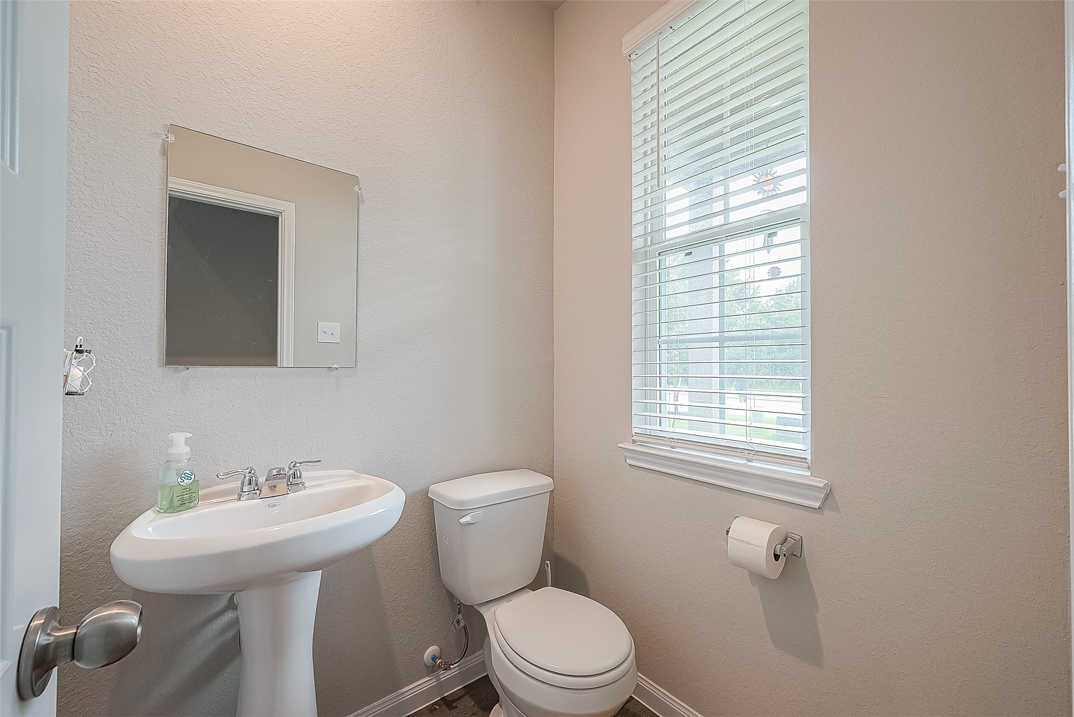 1317 Mount Bassie Trail Conroe, TX 77301 - Photo 9 of 50 a bathroom with a toilet a sink a mirror and a window