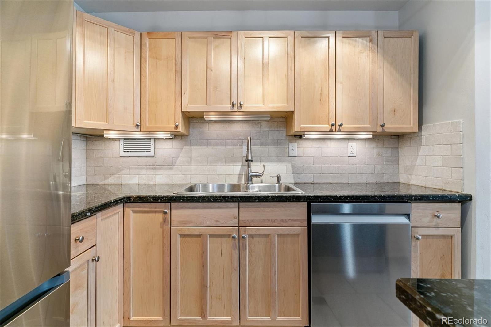 1121 Albion Street, Unit 207 Denver, CO 80220 - Photo 11 of 39 a kitchen with granite countertop a sink and white cabinets