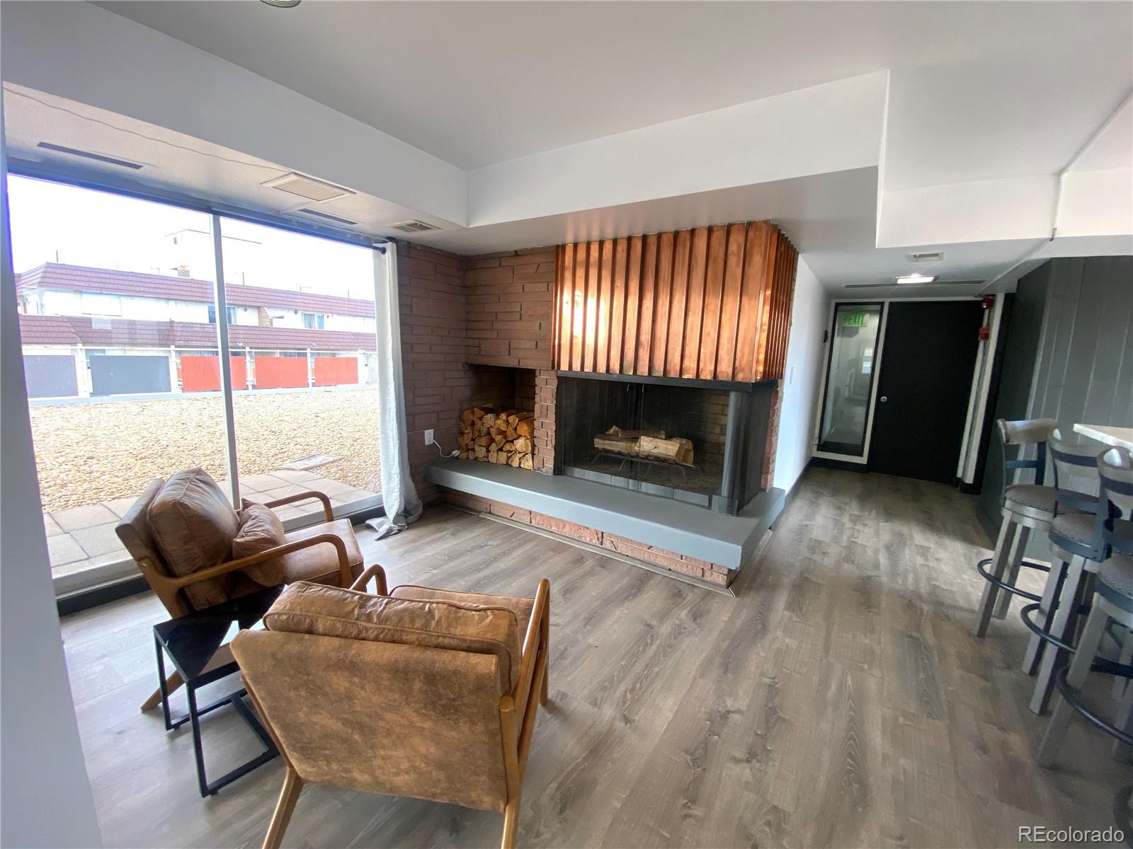 1121 Albion Street, Unit 207 Denver, CO 80220 - Photo 38 of 39 a living room with furniture a fireplace and a floor to ceiling window