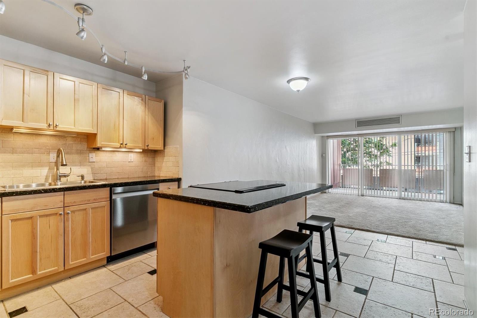 1121 Albion Street, Unit 207 Denver, CO 80220 - Photo 10 of 39 a kitchen with granite countertop a stove sink and cabinets