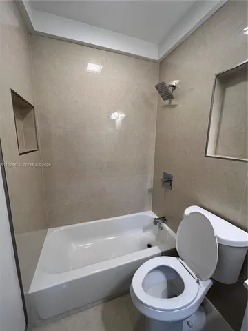 a white toilet sitting next to a bath tub