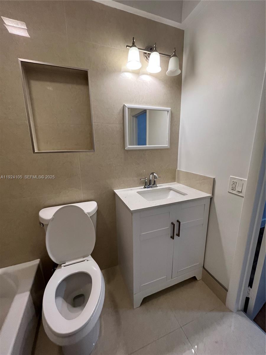 920 Southwest 30th Avenue, Unit 2 Miami, FL 33135 - Photo 12 of 18 a bathroom with a toilet sink and mirror
