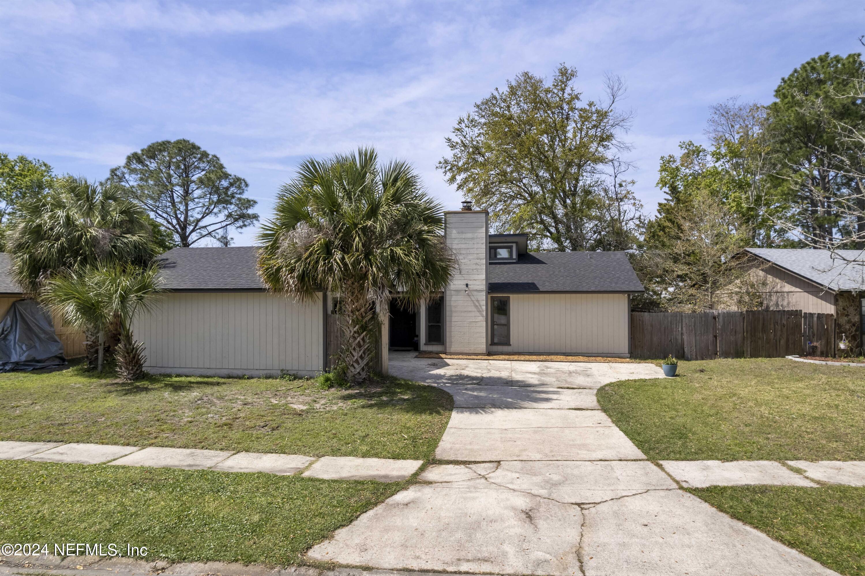 2532 Wattle Tree Road West Jacksonville, FL 32246 - Photo 2 of 25 a front view of a house with a yard and a garage
