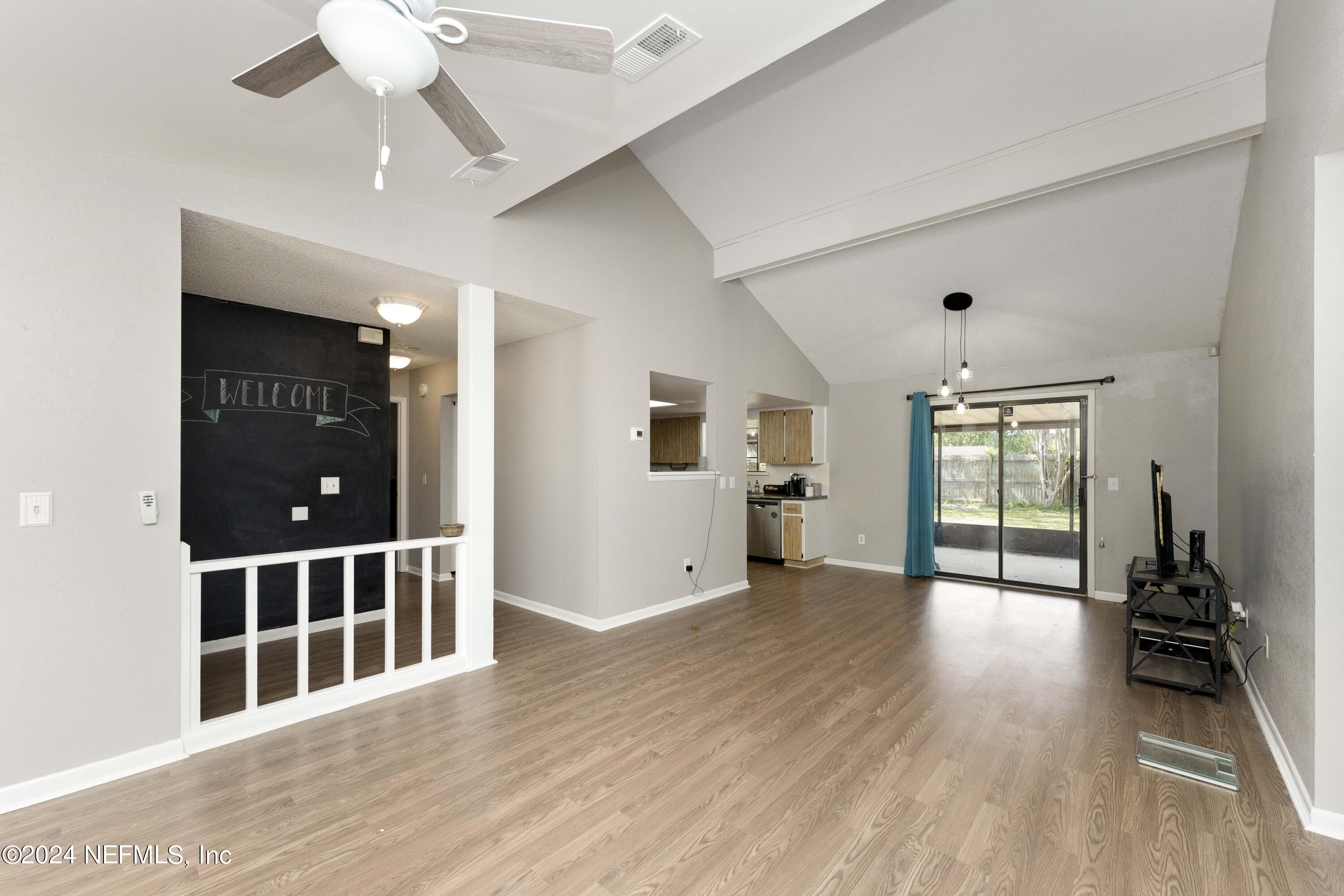 2532 Wattle Tree Road West Jacksonville, FL 32246 - Photo 7 of 25 an empty room with wooden floor fan and windows