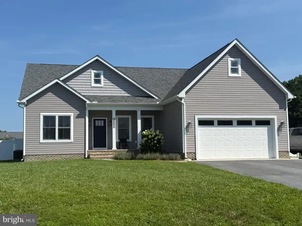 a front view of a house with a garden and yard