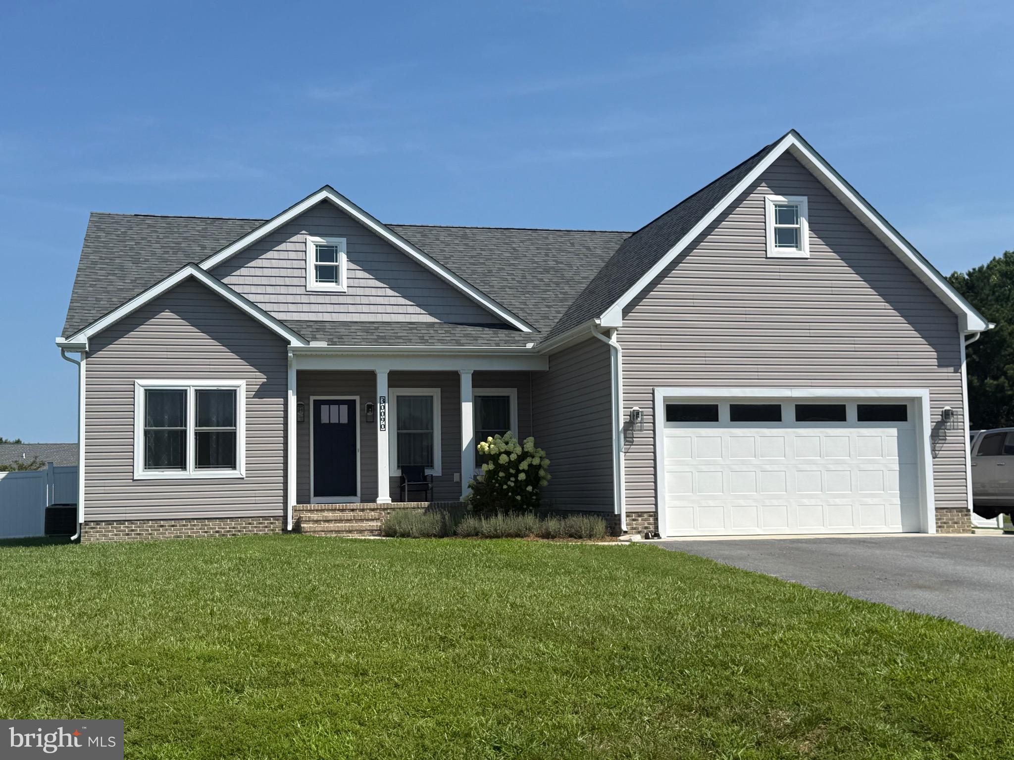 a front view of a house with a garden and yard