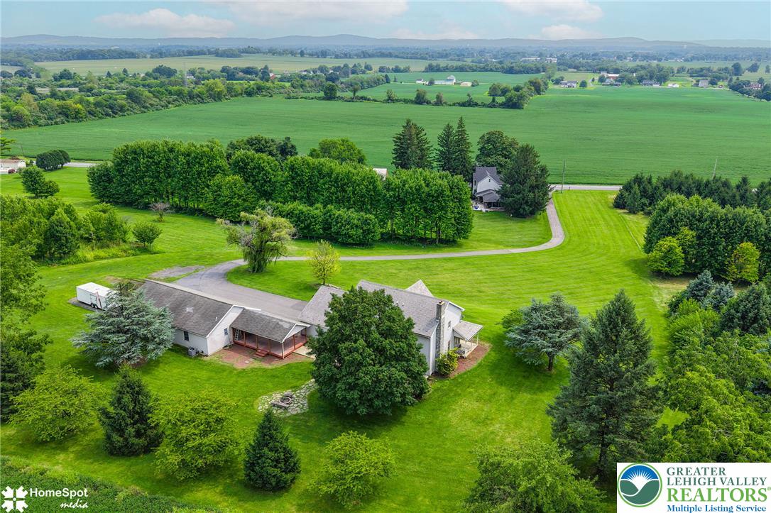 829 Georgetown Road Nazareth, PA 18064 - Photo 48 of 54 A sweeping aerial view showcases the home nestled on expansive green lawns bordering open fields.