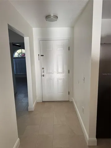 an empty room with mirror and entrance