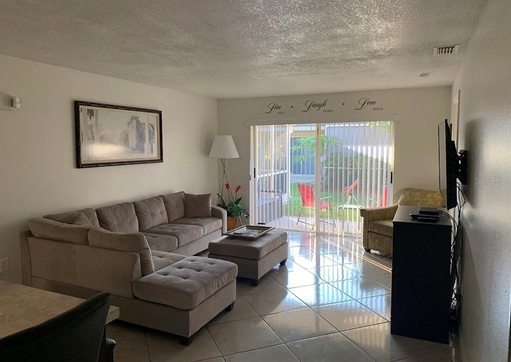 2208 Mystic Ring Loop Kissimmee, FL 34759 - Photo 2 of 12 a living room with furniture and a flat screen tv
