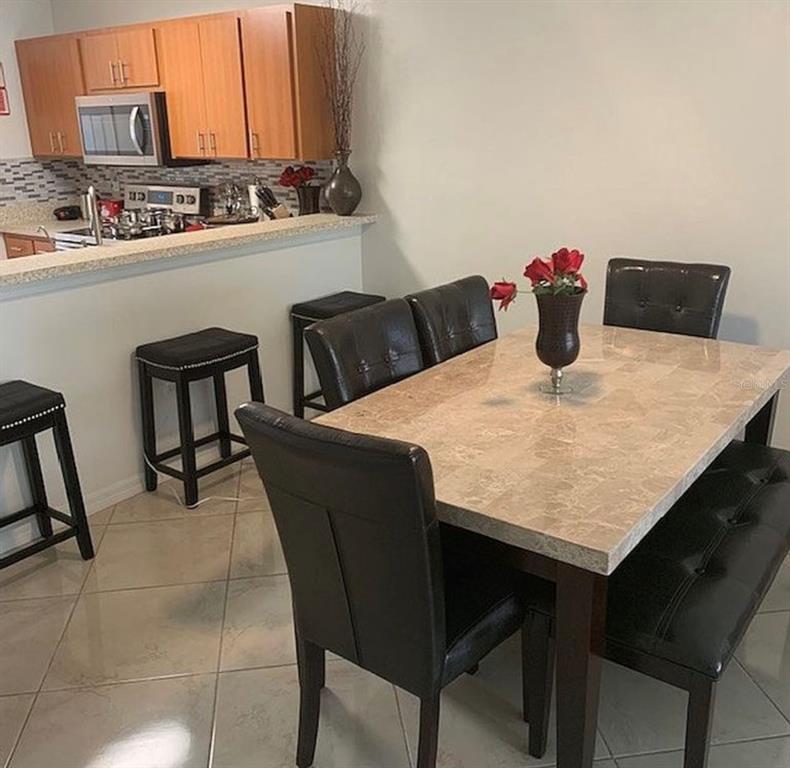 2208 Mystic Ring Loop Kissimmee, FL 34759 - Photo 3 of 12 a kitchen with stainless steel appliances kitchen island chair and wooden cabinets