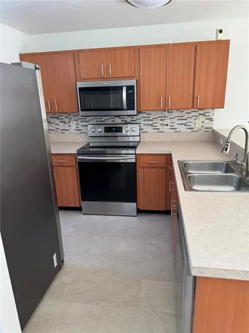 a kitchen with granite countertop a sink and a stove top oven