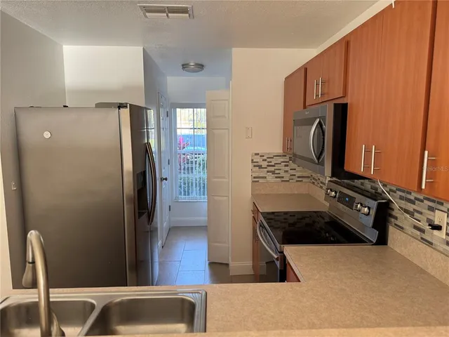 a kitchen with stainless steel appliances granite countertop a refrigerator and a stove