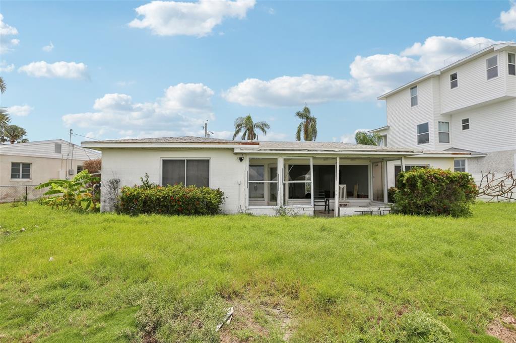16033 Redington Drive Redington Beach, FL 33708 - Photo 15 of 26 a view of a white house with a big yard and large trees