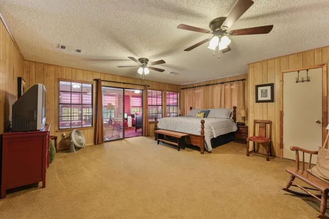 a bedroom with a large bed and large windows
