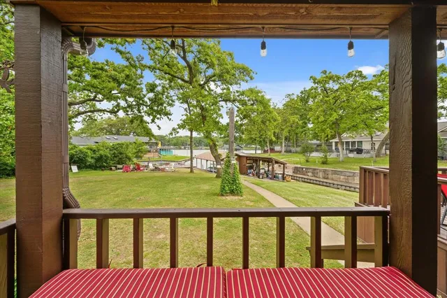 a view of a patio with lawn chairs and couches with wooden floor next to a yard