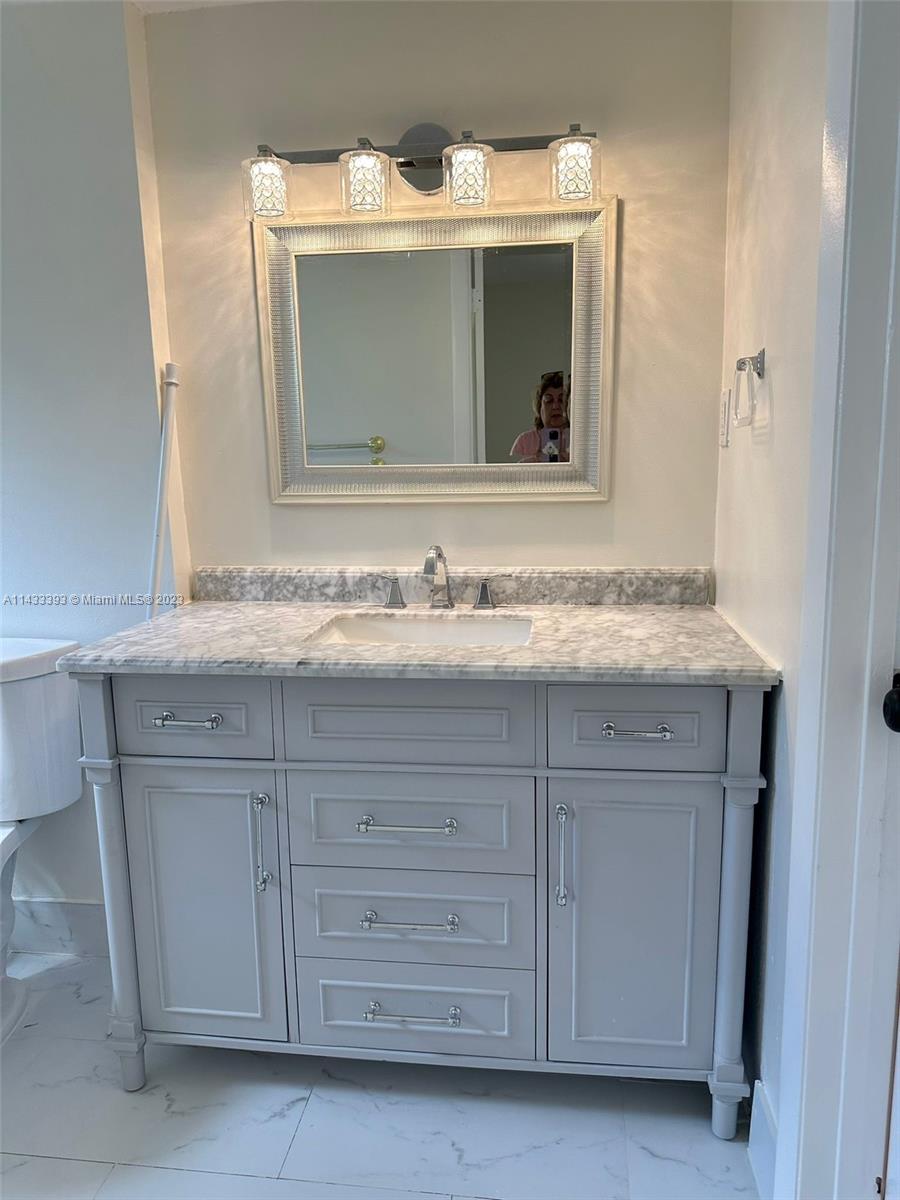 8327 Southwest 137th Avenue, Unit 8327 Miami, FL 33183 - Photo 13 of 31 a bathroom with a granite countertop sink vanity and mirror