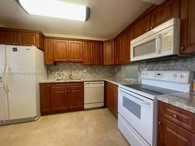 8327 Southwest 137th Avenue, Unit 8327 Miami, FL 33183 - Photo 4 of 31 a kitchen with stainless steel appliances granite countertop a refrigerator stove a sink and dishwasher with wooden floor