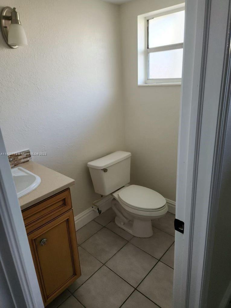 8327 Southwest 137th Avenue, Unit 8327 Miami, FL 33183 - Photo 5 of 31 a bathroom with a toilet a sink a vanity and mirror