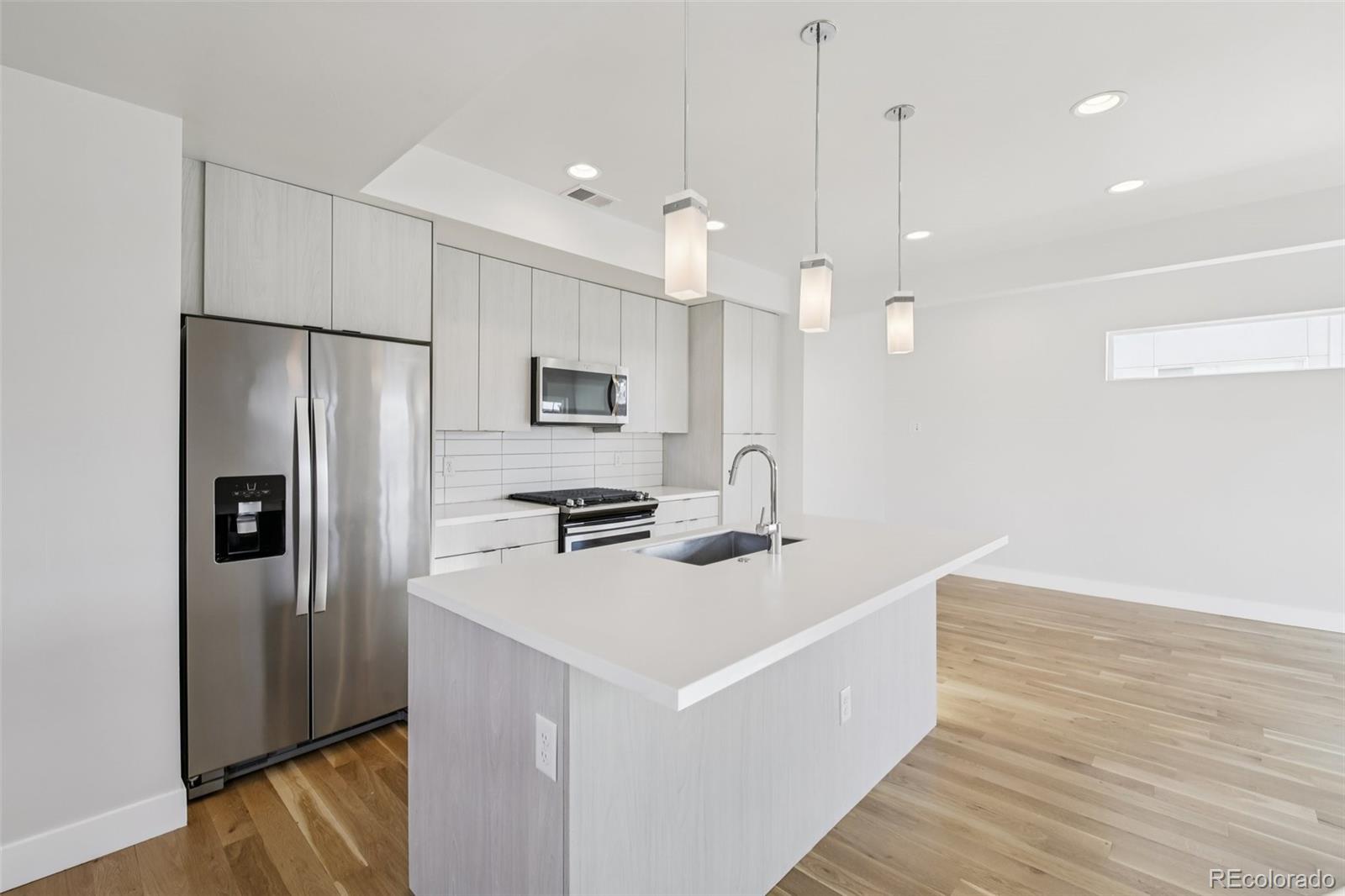 1274 Quitman Street, Unit 6 Denver, CO 80204 - Photo 11 of 50 a kitchen with stainless steel appliances a refrigerator a sink and a stove
