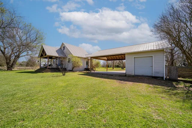 a view of a house with a yard and garage