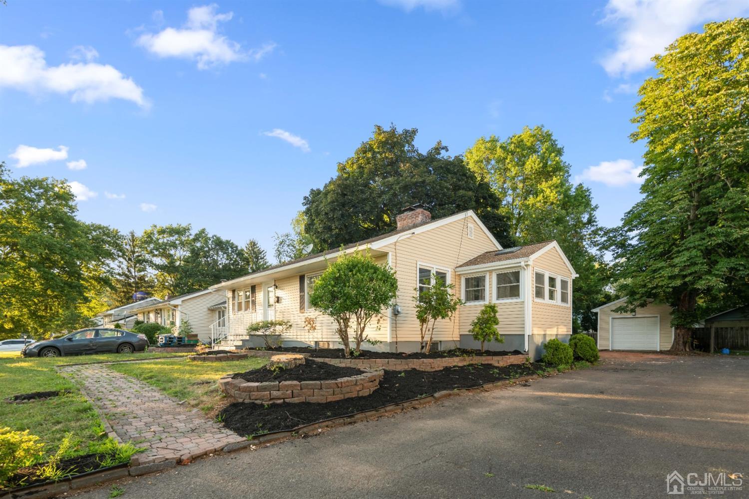 282 Lawrence Avenue North Plainfield, NJ 07063 - Photo 2 of 27 a front view of a house with a garden and trees