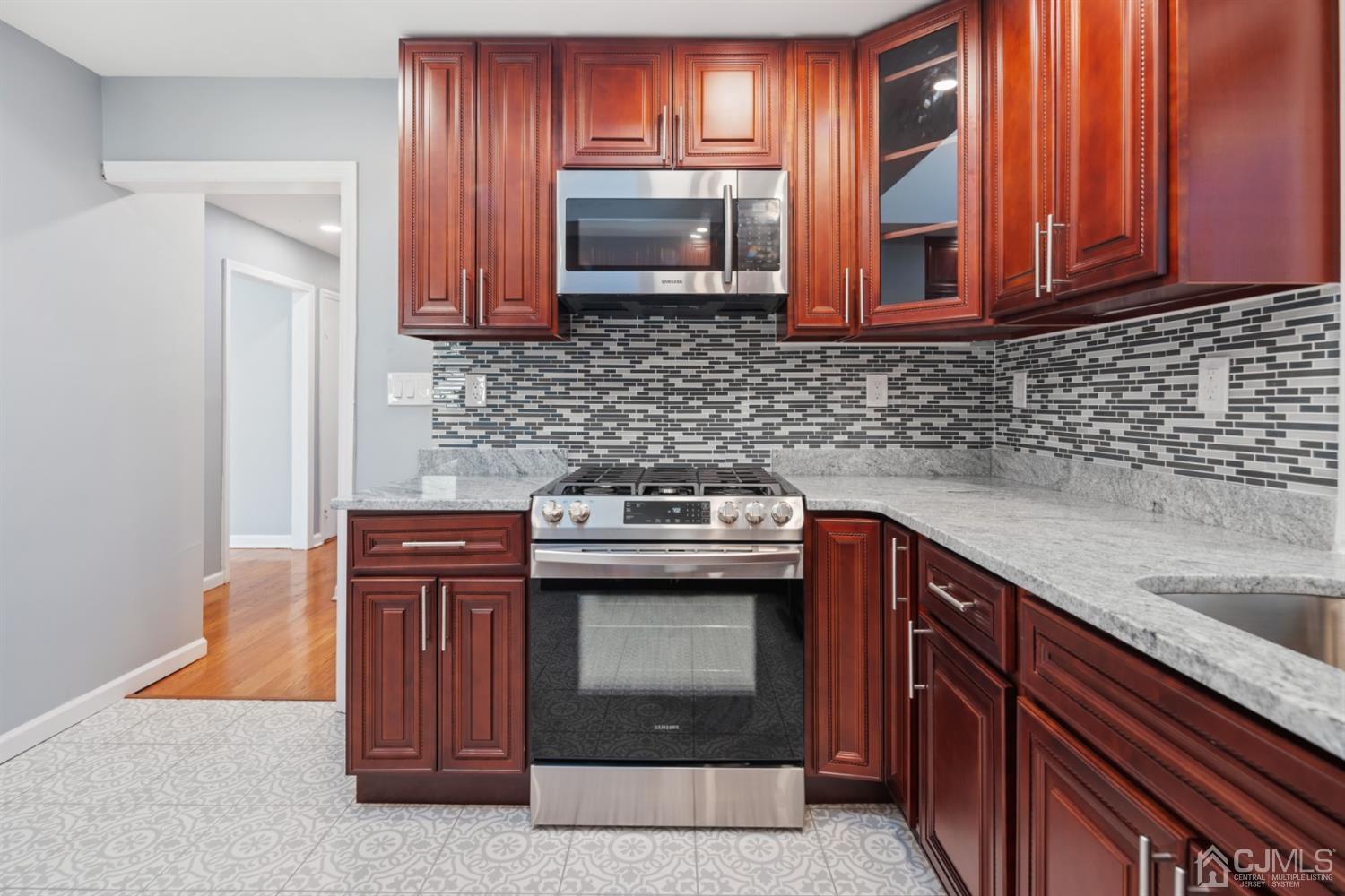 282 Lawrence Avenue North Plainfield, NJ 07063 - Photo 13 of 27 a kitchen with stainless steel appliances granite countertop a sink stove and microwave