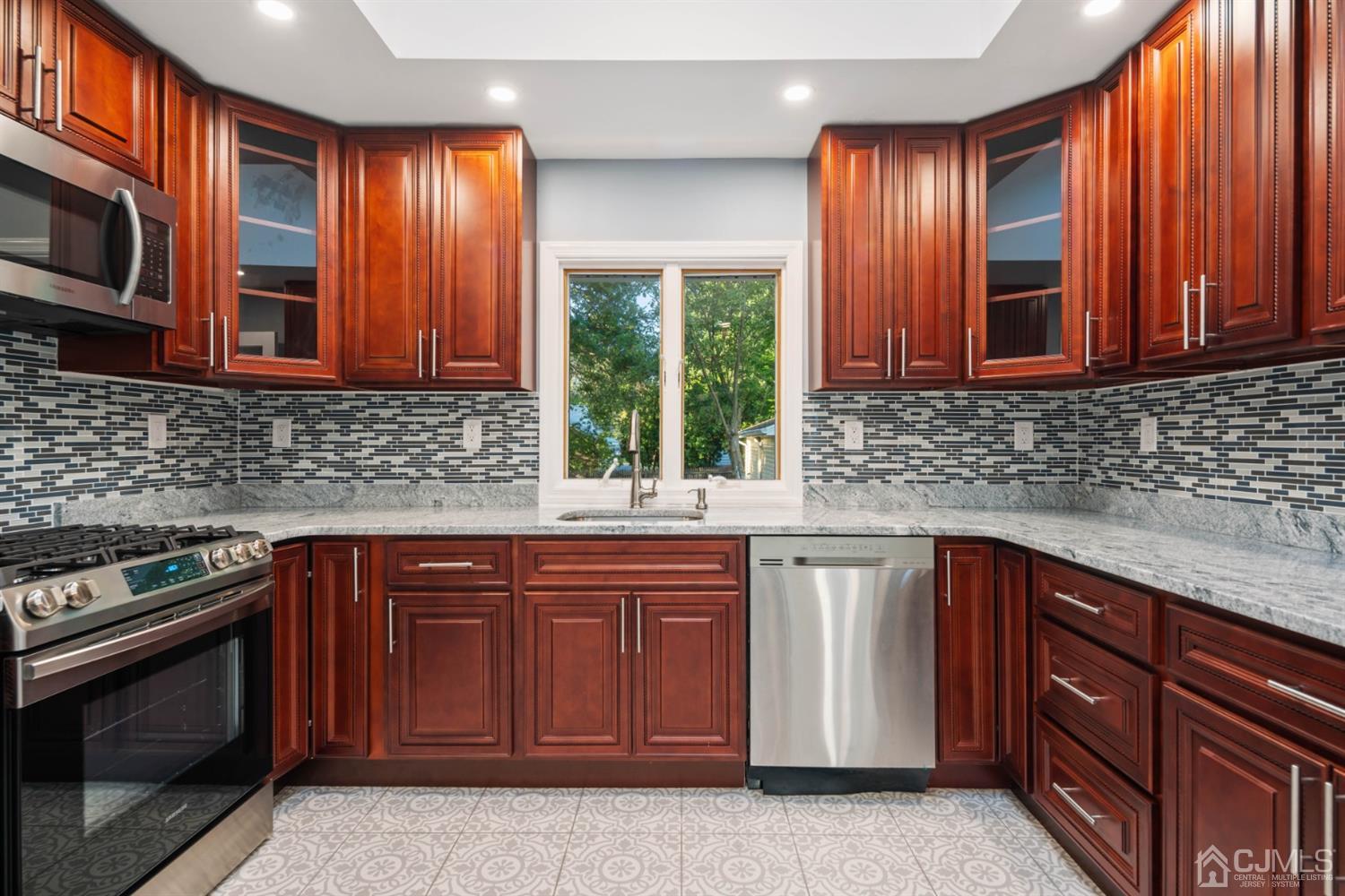 282 Lawrence Avenue North Plainfield, NJ 07063 - Photo 17 of 27 a kitchen with stainless steel appliances granite countertop wooden cabinets a sink and a stove