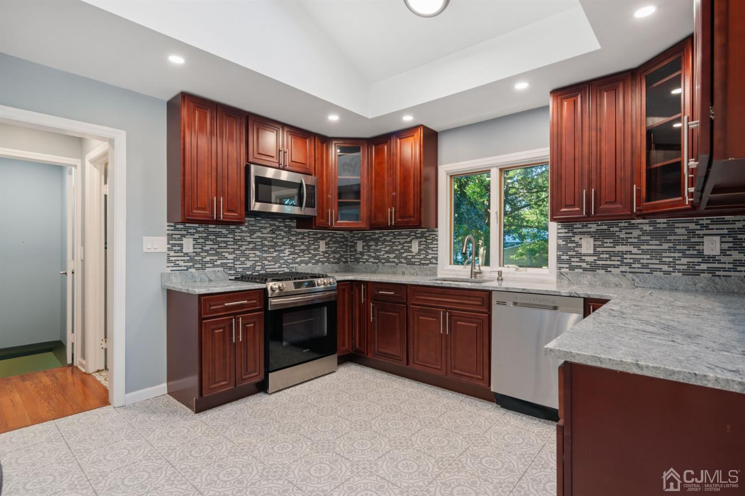 282 Lawrence Avenue North Plainfield, NJ 07063 - Photo 18 of 27 a kitchen with stainless steel appliances granite countertop wooden cabinets a stove top oven a sink and dishwasher