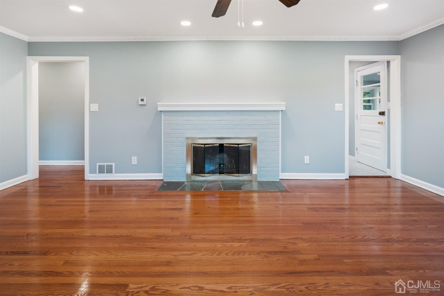 282 Lawrence Avenue North Plainfield, NJ 07063 - Photo 4 of 27 a view of empty room with wooden floor and fireplace