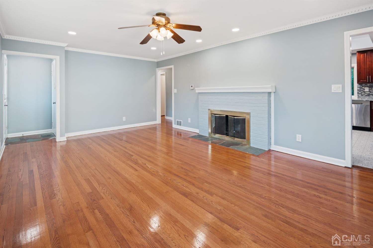 282 Lawrence Avenue North Plainfield, NJ 07063 - Photo 5 of 27 an empty room with wooden floor fireplace and windows
