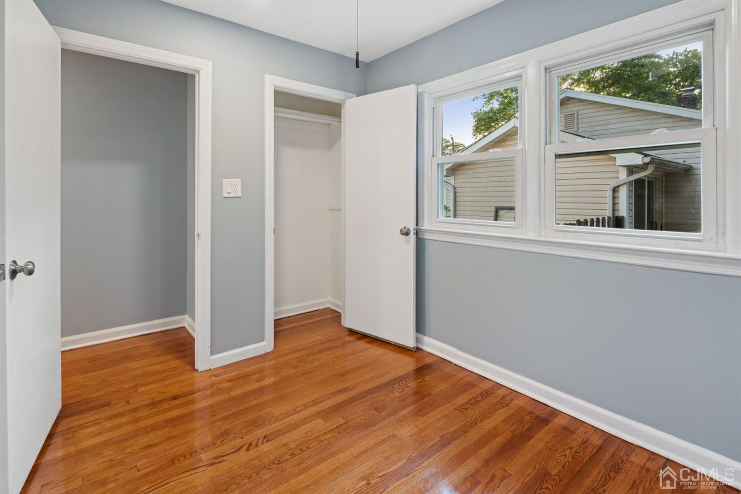 282 Lawrence Avenue North Plainfield, NJ 07063 - Photo 7 of 27 a view of an empty room with wooden floor and a window