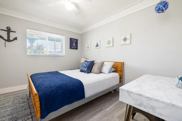 a bedroom with a bed and a flat tv screen on the dresser