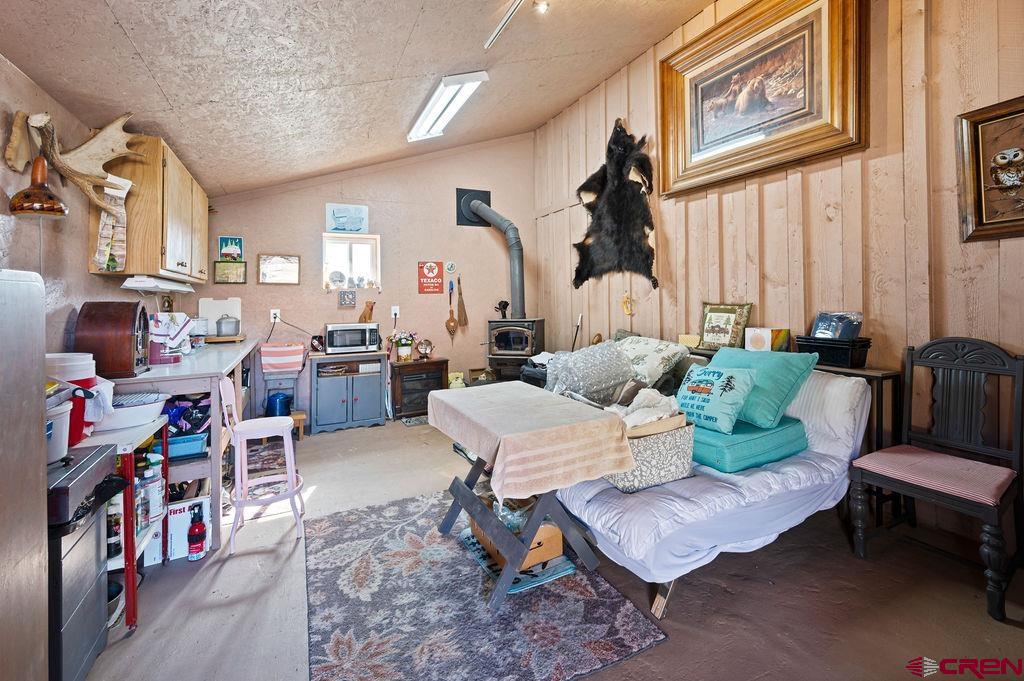 18726 58 6/10 Road Collbran, CO 81624 - Photo 19 of 38 Interior space featuring lofted ceiling and a wood stove