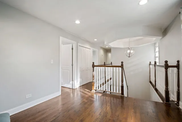 a view of a hallway with wooden floor and staircase