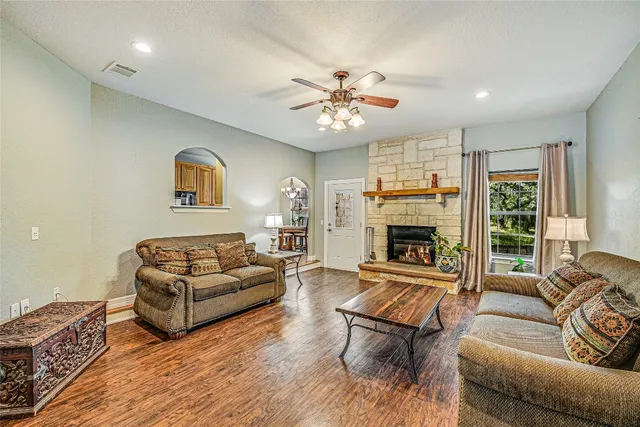 a living room with furniture ceiling fan and a fireplace