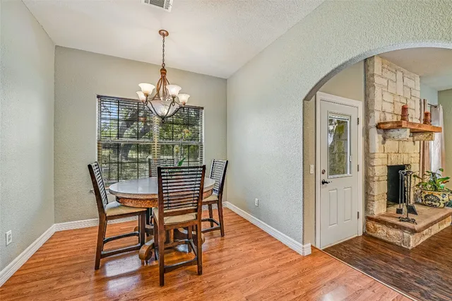 a dining room with furniture a chandelier and wooden floor