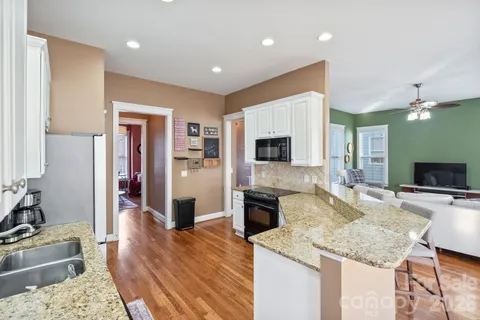 a kitchen with stainless steel appliances granite countertop a sink refrigerator and cabinets