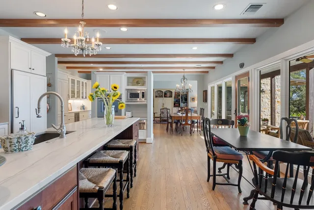 a dining room with furniture a chandelier and wooden floor