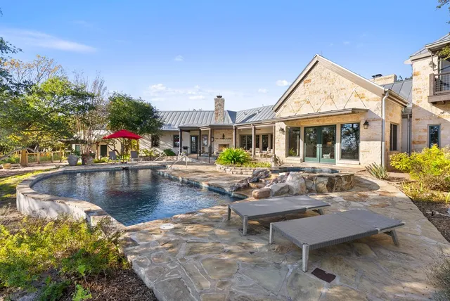 a view of a house with pool and chairs