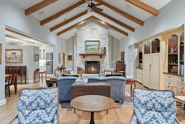 a living room with furniture a fireplace and a chandelier