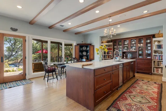 a kitchen with stainless steel appliances kitchen island granite countertop a table and chairs in it