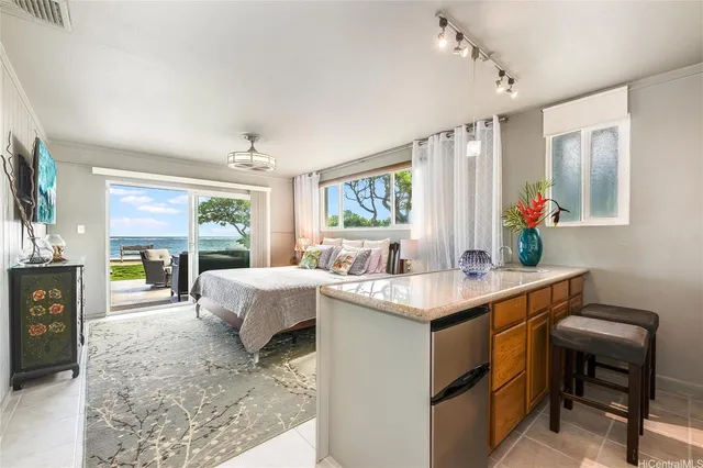 a kitchen with a stove and a view of living room