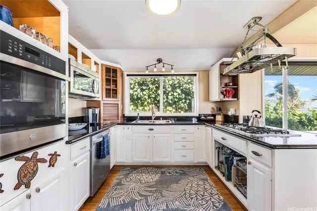 a kitchen with stainless steel appliances a sink a stove and a wooden floors
