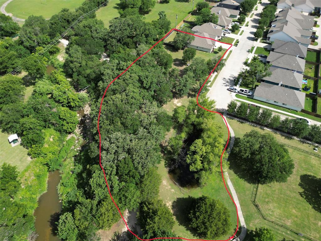 229 Firefly Drive Springtown, TX 76082 - Photo 31 of 33 Expansive land parcel featuring mature trees, a natural water feature, and a paved pathway