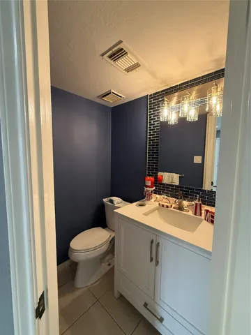 a bathroom with a sink vanity mirror and toilet