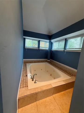a bathroom with a tub and window