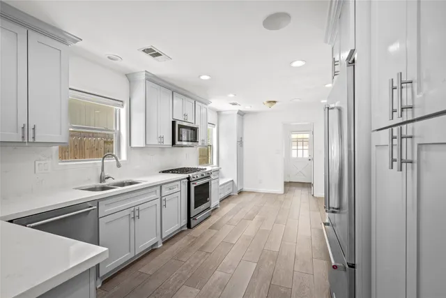 a kitchen with a sink appliances and cabinets