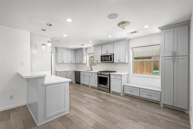 a open kitchen with white cabinets and stainless steel appliances