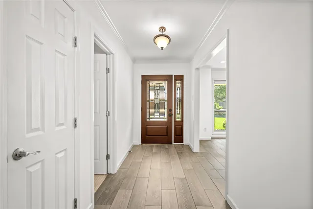 a view of a hallway with wooden floor and closet
